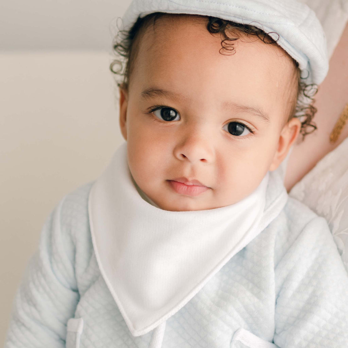 Baby boy wearing the Asher Bandana Bib made from a white French Terry cotton with button closure. 