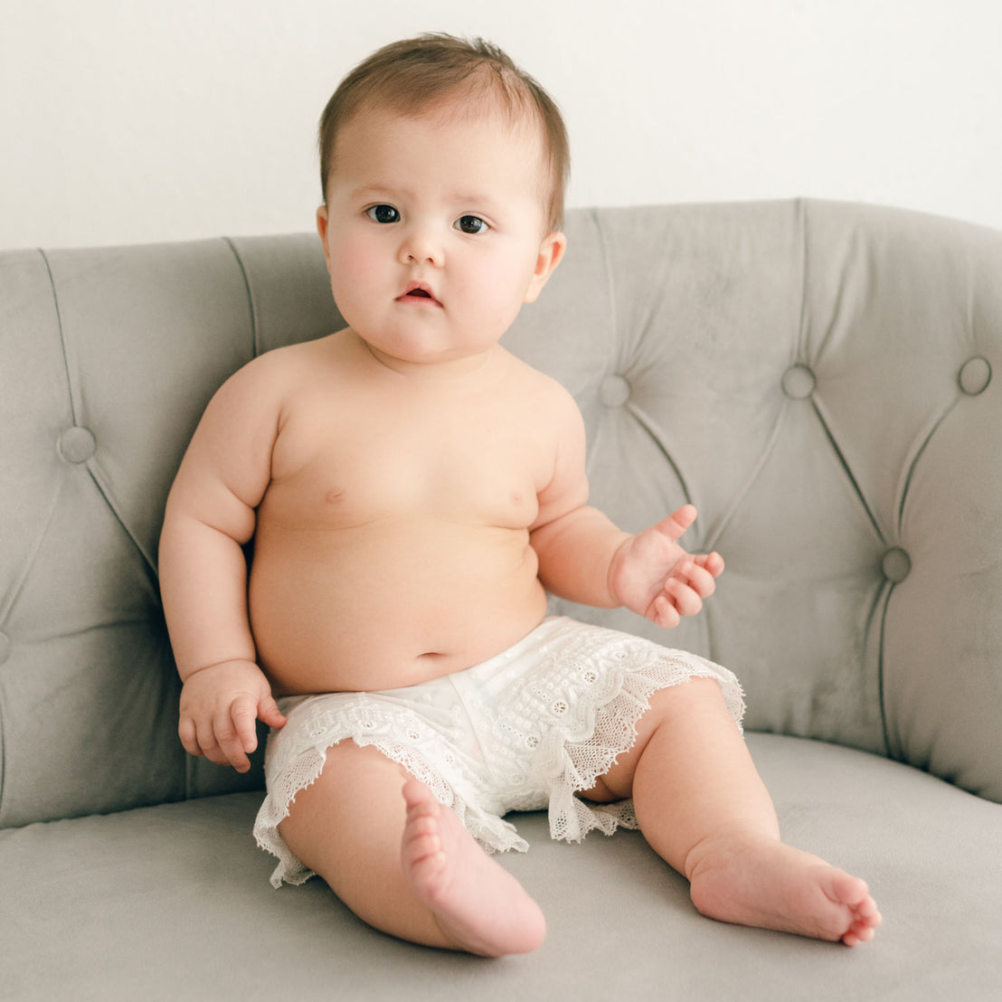 Baby girl wearing the Emily Bloomers made in a wide leg style with embroidered cotton eyelet lace with scalloped edge and lace trim.