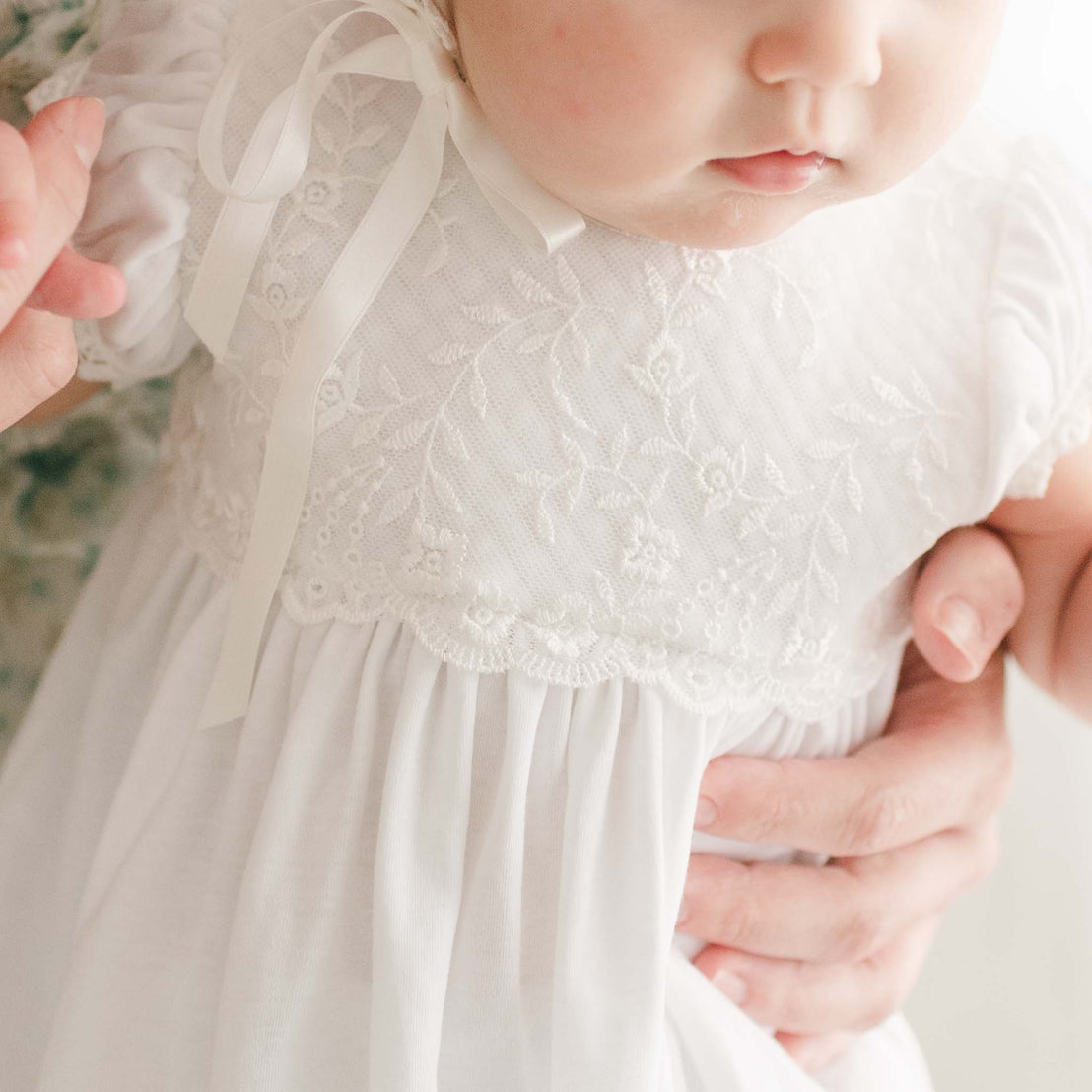 Photo showcasing the floral lace detail on the Ella Layette Gown.