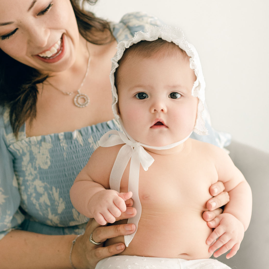 Baby girl with her mother. She is wearing the Emily Bonnet and Bloomers.