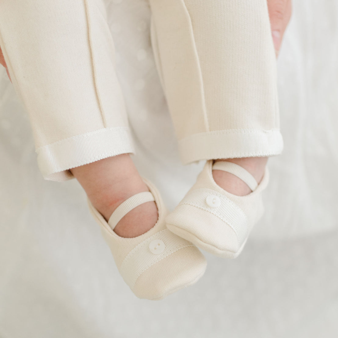 Photo of a baby wearing the Braden Booties made from ivory french terry cotton