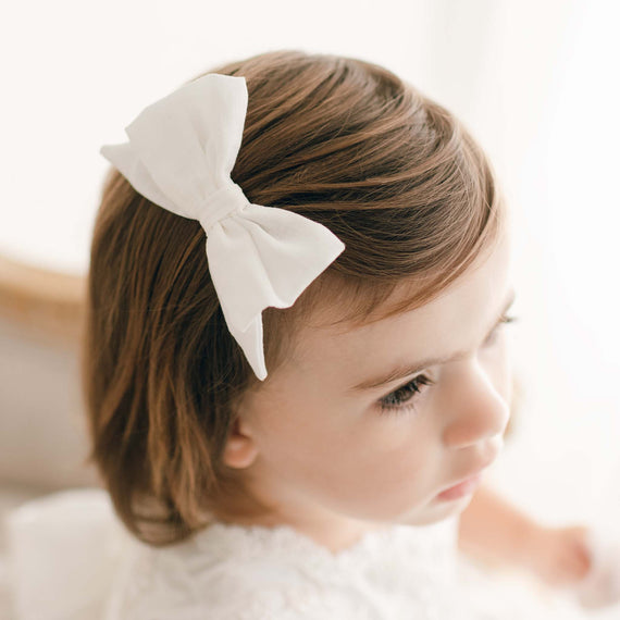 Close up photo of the baby girl silk christening bow.