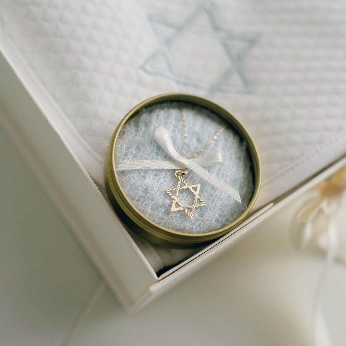 Star of David charm necklace in blue knit lined tin.