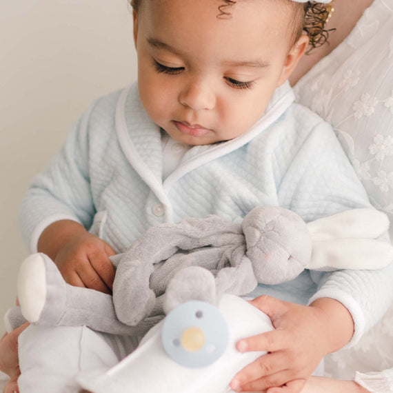 Baby boy with the Asher Silly Bunny Buddy, a soft stuffed animal bunny (made from a soft velour in grey) that holds on to a pacifier.