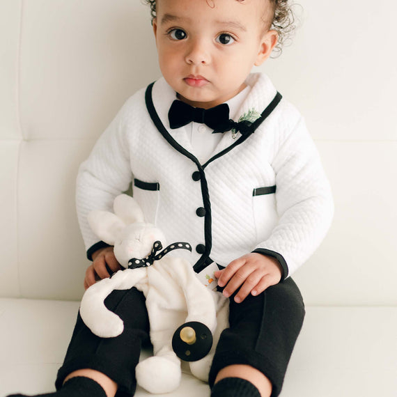 Baby boy with the James Silly Bunny Buddy, a white floppy stuffed animal bunny made from soft velour and can hold on to a pacifier. 