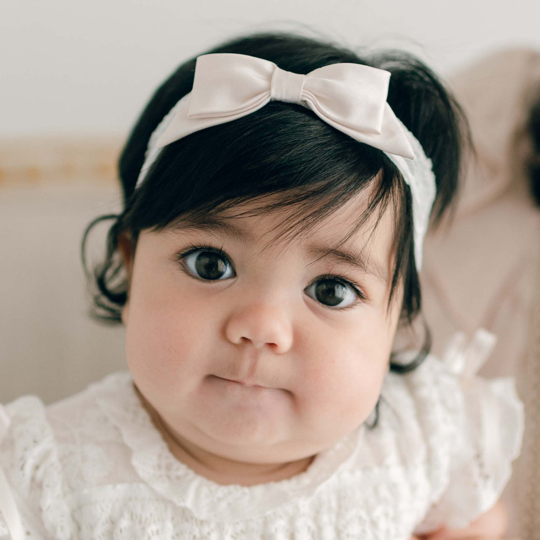 A delicate pink champagne-colored silk bow tied in the center of a Charlotte Accessory Bundle - Save 15%, positioned on a soft, light background.