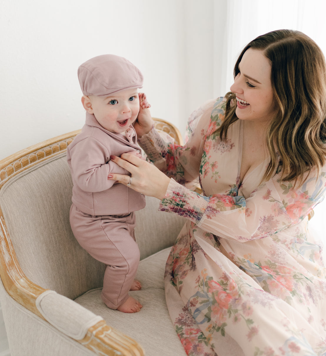 Smiling baby boy in mauve suit with mom 