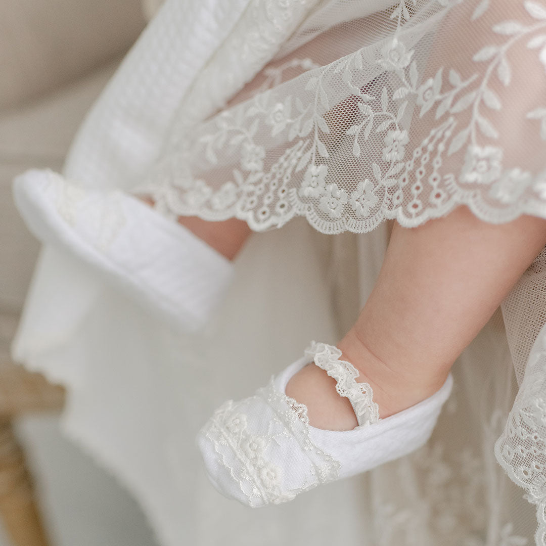 Closeup of a baby girl wearing Ella Booties, featuring delicate details of the cotton and lace.