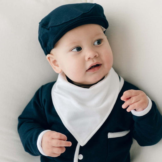 Baby boy wearing the Elliott Bandana Bib that matches the Elliott 3-Piece Suit. The bib is made from white French Terry cotton. 