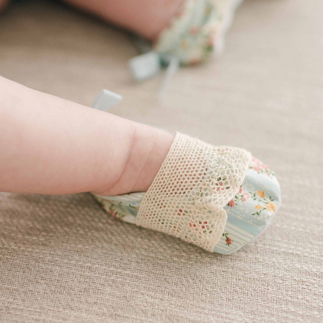 Closer detail of the "Powder Blue" Eloise Booties made with the matching Eloise floral striped material and showcasing the natural color lace across the toe and a coordinating cotton ribbon bow on the heel.