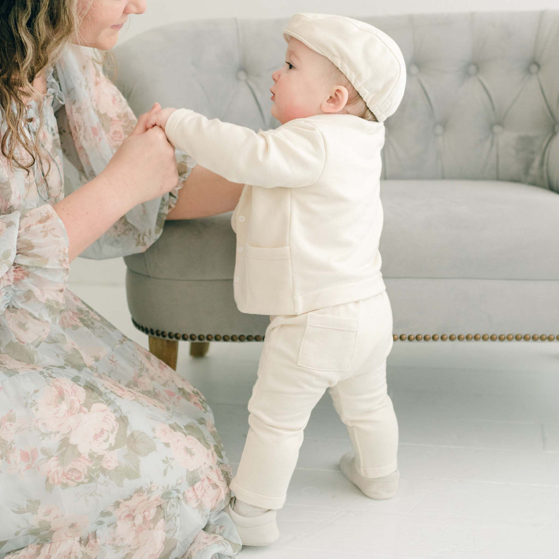 Walking baby boy guided by his mother. He is wearing the Ezra Tan 4-Piece Suit