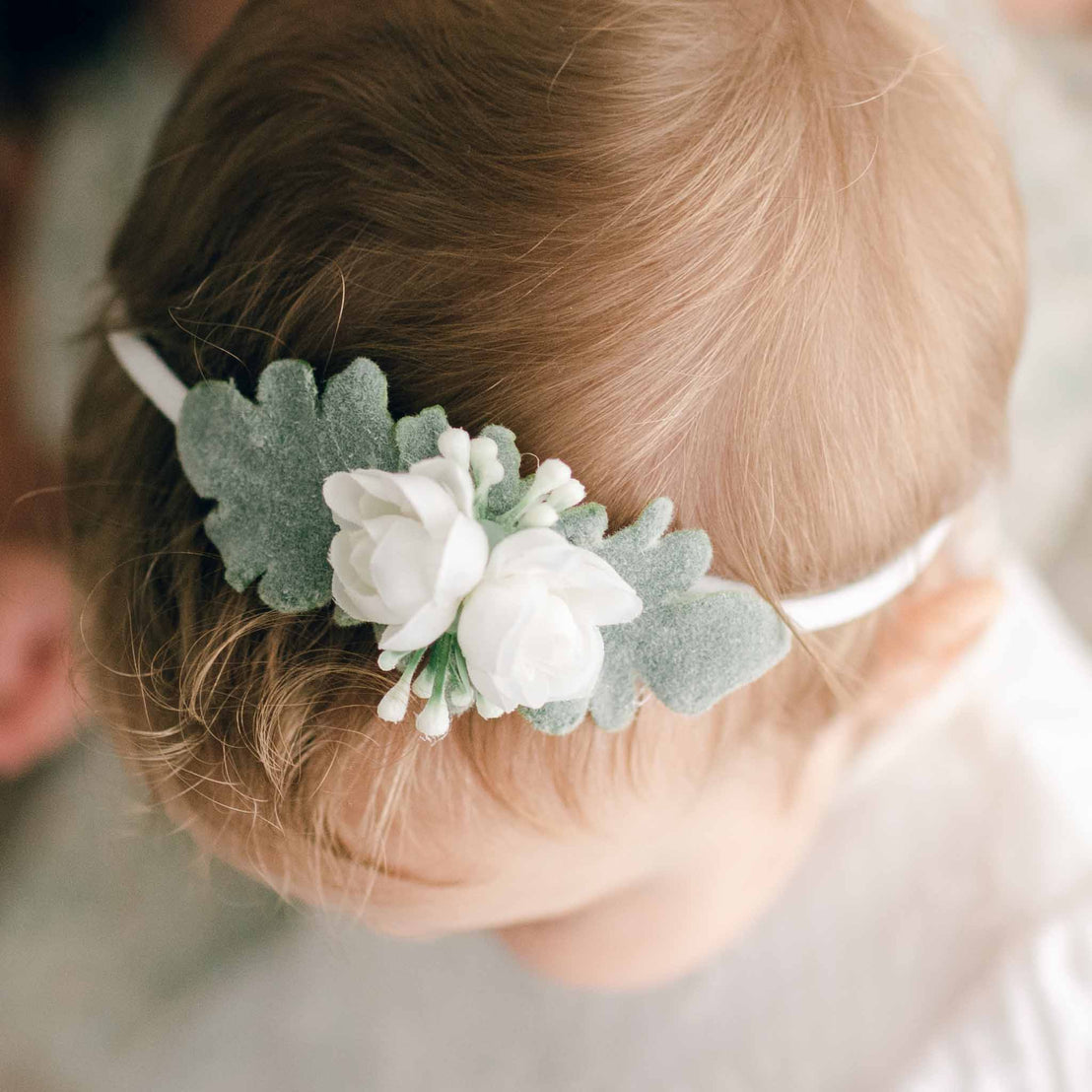 Close-up of the boutique quality Ella Petite Flower Headband as worn by a baby.