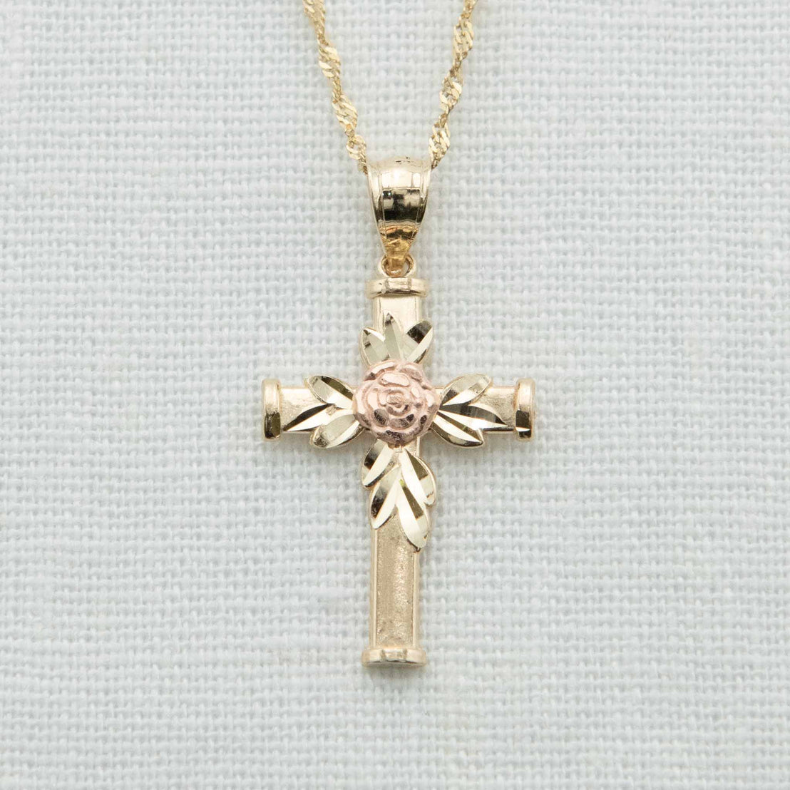 Solid gold cross with gold leaves and rose gold rose detail on chain