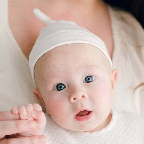 Newborn baby wearing the Owen Knot Cap made from an ivory soft pima cotton with a knot design