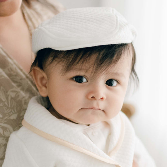 Close up photo showcasing the Liam Baby Newsboy Cap made from white quilt