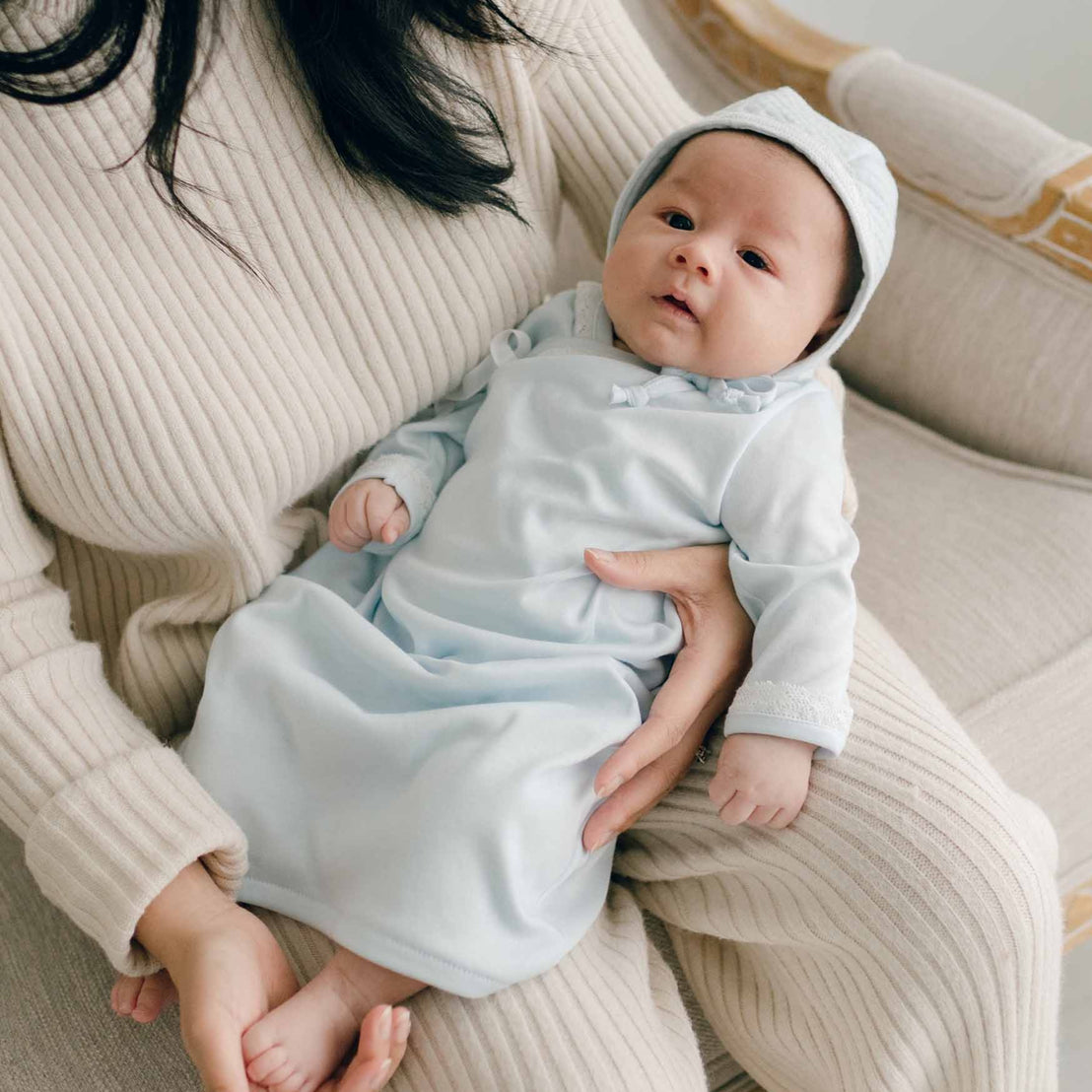 Baby with Mom, wearing blue pima newborn gown and quilted cotton bonnet