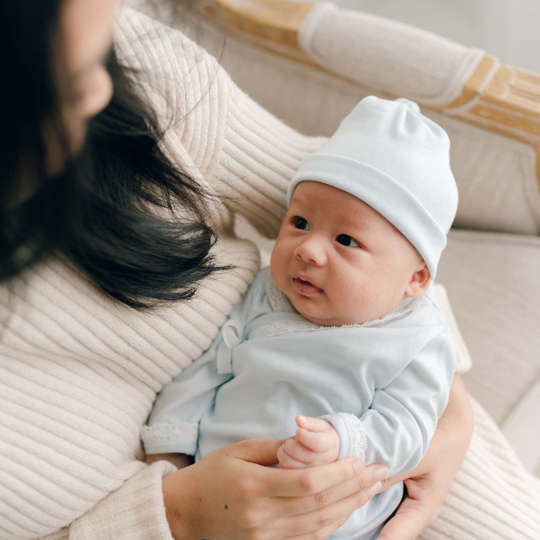 Baby with Mom, wearing blue pima newborn gown and pima cotton knot cap