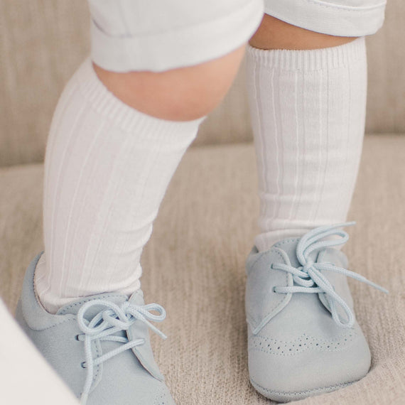 Baby wearing the white Ribbed Knee Socks made from a cotton blend and featuring a ribbed pattern 