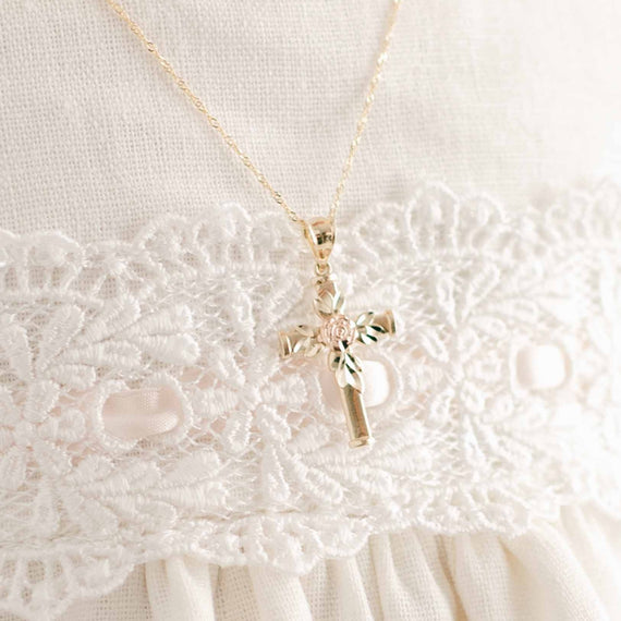 Rose gold rose on gold cross necklace on baby