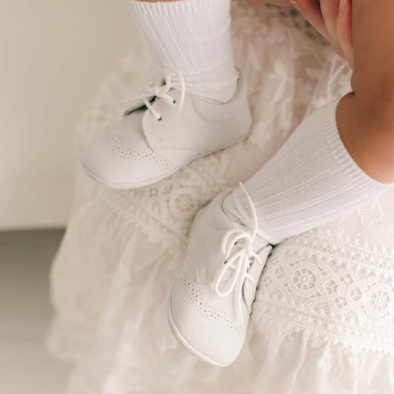 Baby boy wearing the dove grey Asher Suede Shoes. Made from a super soft suede with detailed edging and shoelaces. 