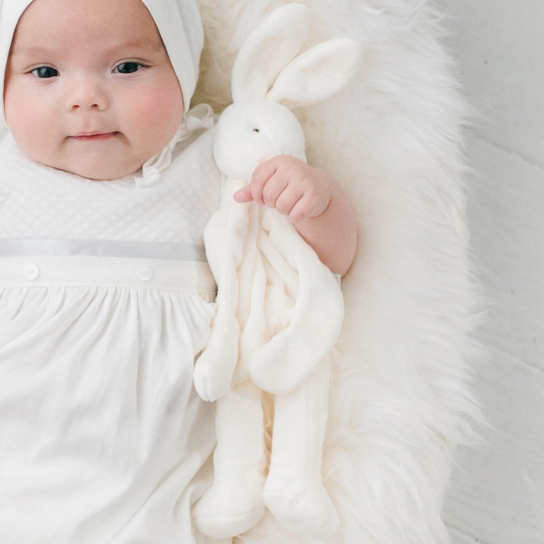 Newborn baby boy wearing the Owen Layette. He is also holding the Owen Silly Bunny Buddy