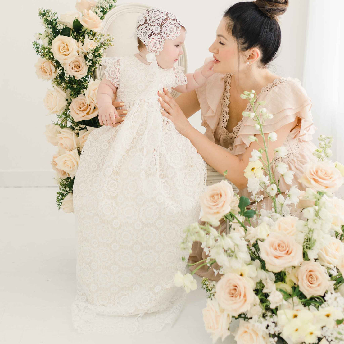 Photo of baby girl in her Poppy cotton baptism gown with her mom. 