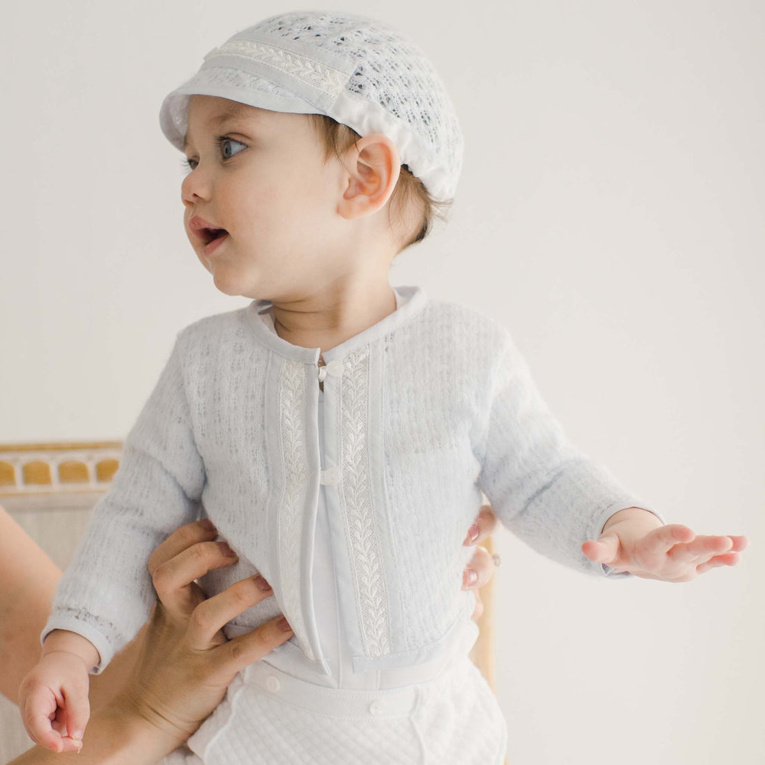 A smiling baby boy wearing the Harrison Blue Knit Sweater and matching Harrison Blue Knit Hat