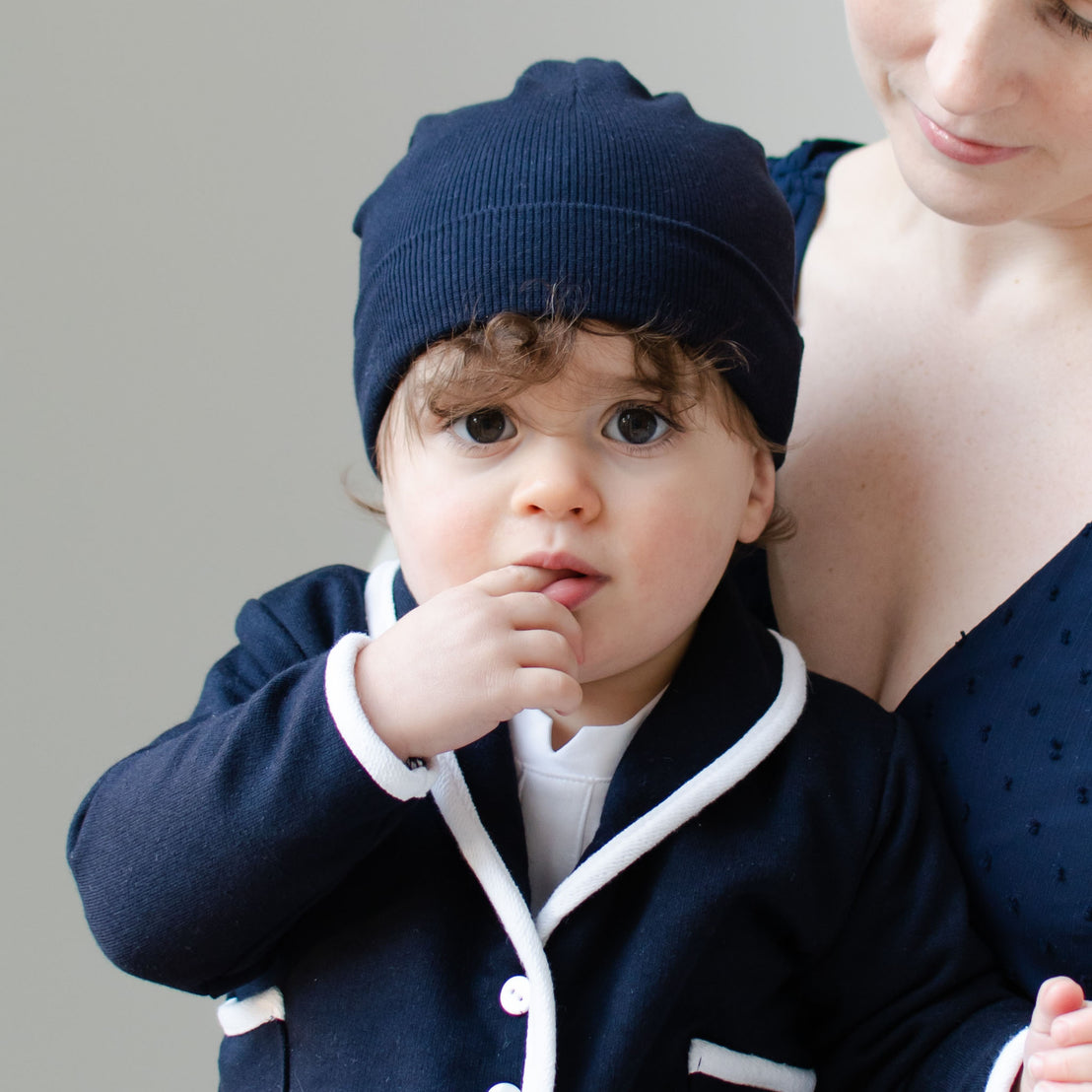 Baby boy with his mother. He is wearing the Navy Ribbed Cotton Beanie.