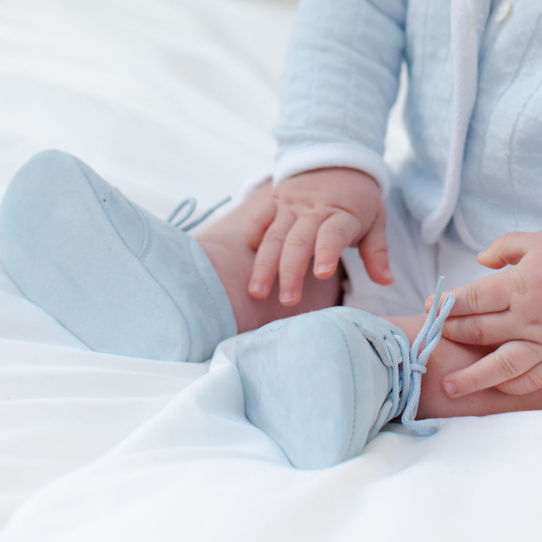 Baby boy wearing the Sky Blue Suede Shoes made from 100% Suede with detailed edging.