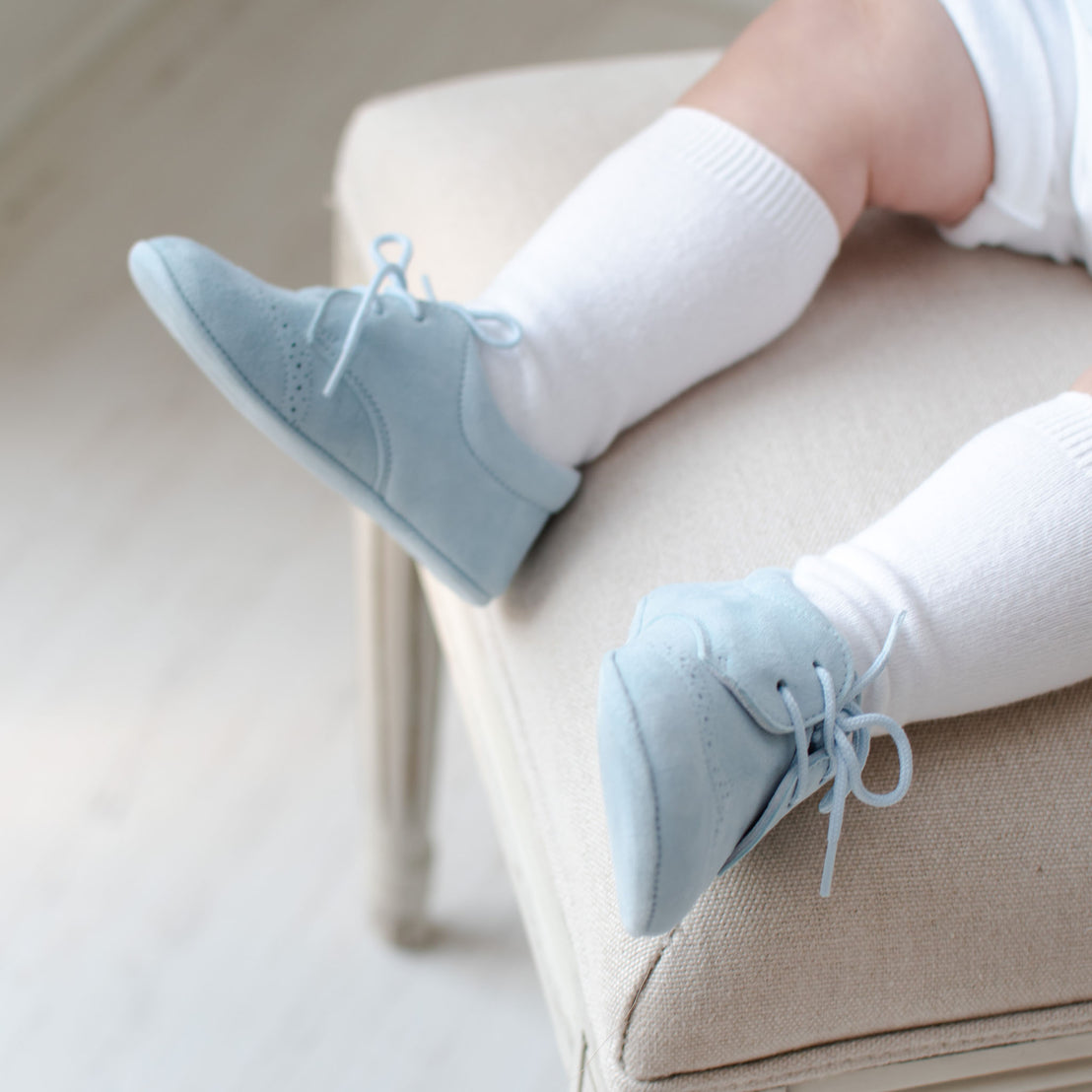 Baby boy wearing the Sky Blue Suede Shoes made from 100% Suede with detailed edging.