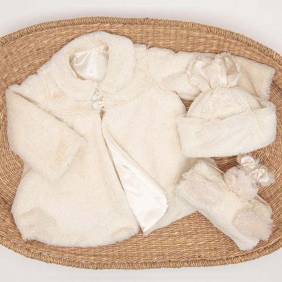 The Glad Dreams Coat Set includes a cozy infant clothing set with a faux fur baby coat, matching hat adorned with a bow, and mittens all presented on a woven mat. The coat features a satin lining and decorative buttons, making it an exceptional baby gift for keeping your little one warm and stylish.