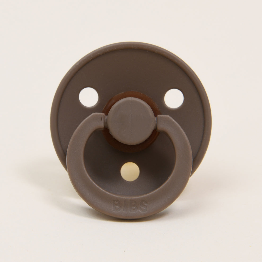 A Bibs Pacifier in "dark oak" on a white background featuring three ventilation holes and a protruding handle.