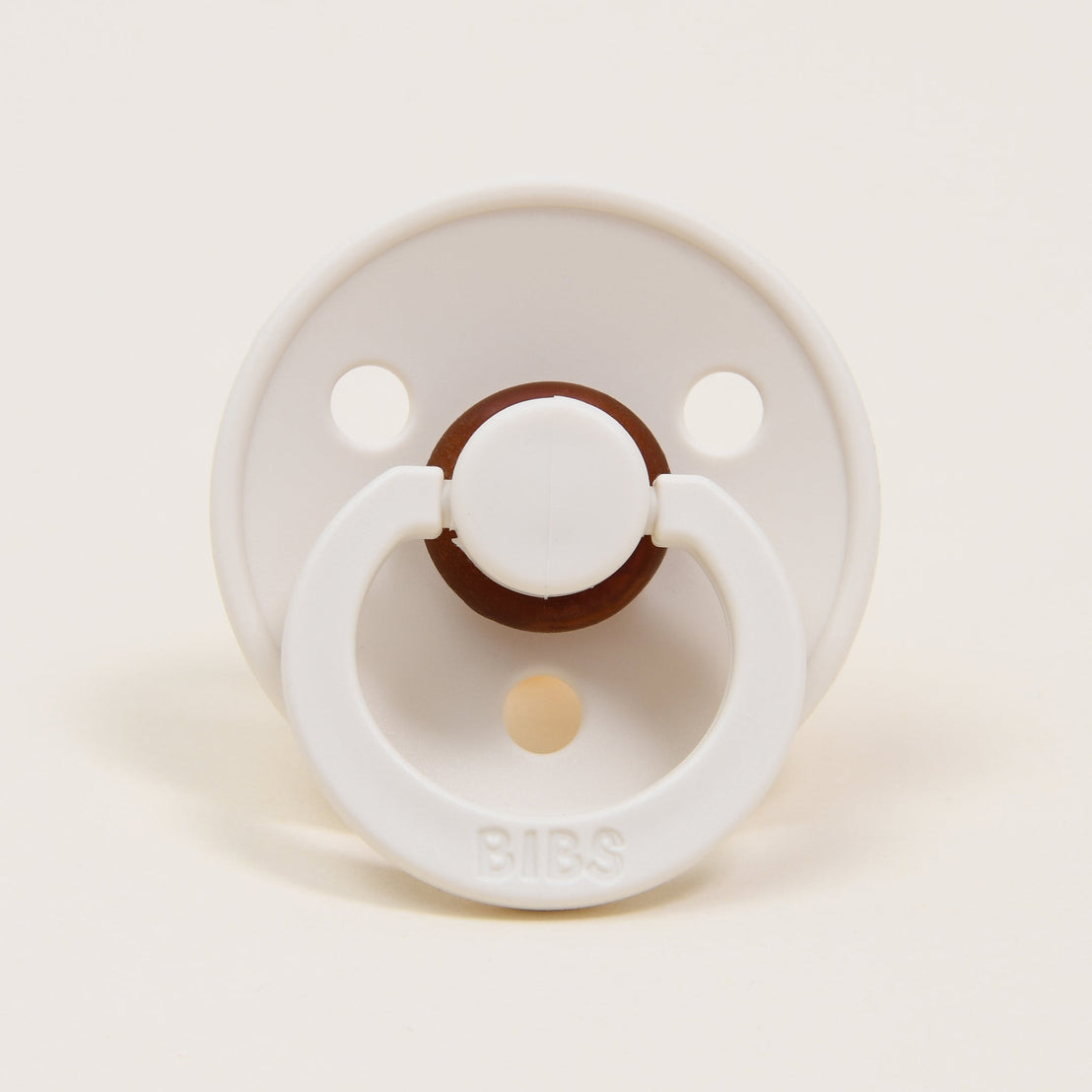 A bibs pacifier in "ivory" color and set against a white background.. 