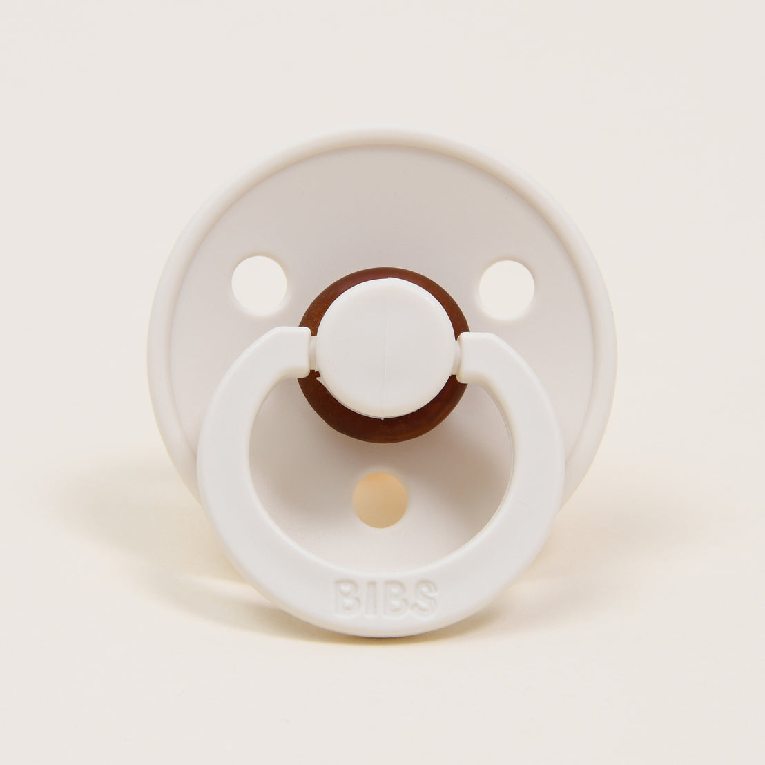 An Ivory colored pacifier displayed against a solid light background.