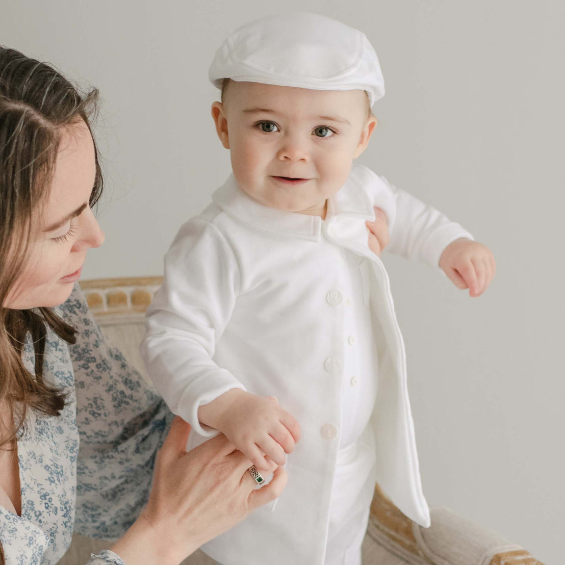 Smiling baby boy wearing the Miles Trench Coat made from white french terry cotton