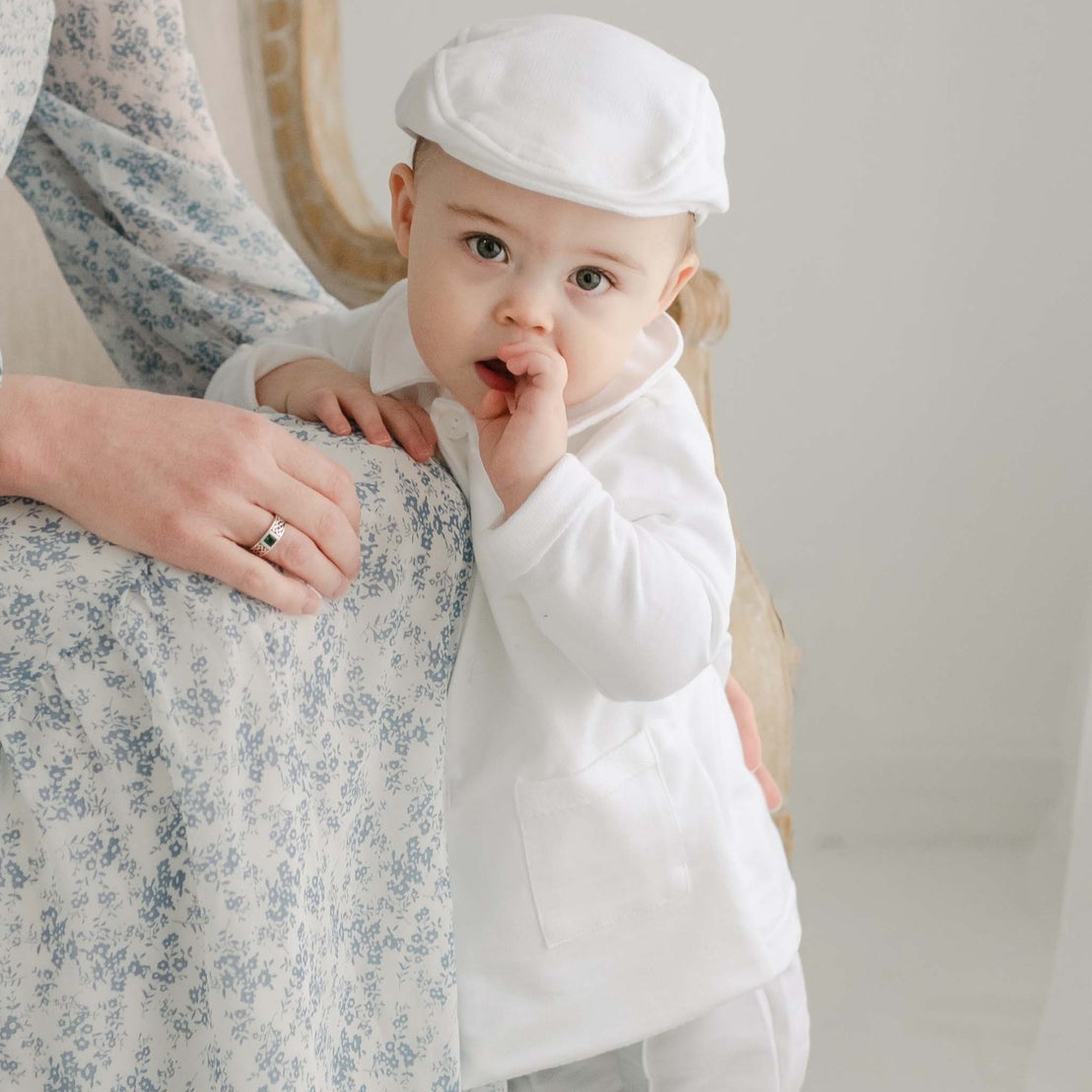 Baby boy with his mother. He is wearing the Miles Trench Coat made from white french terry cotton