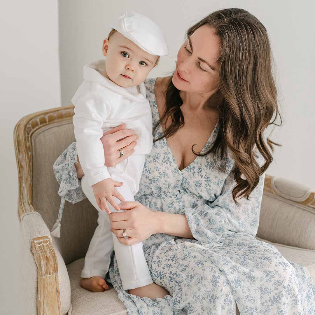 Photo of a baby boy being held by his mother. He is wearing the Miles 3-Piece Suit 