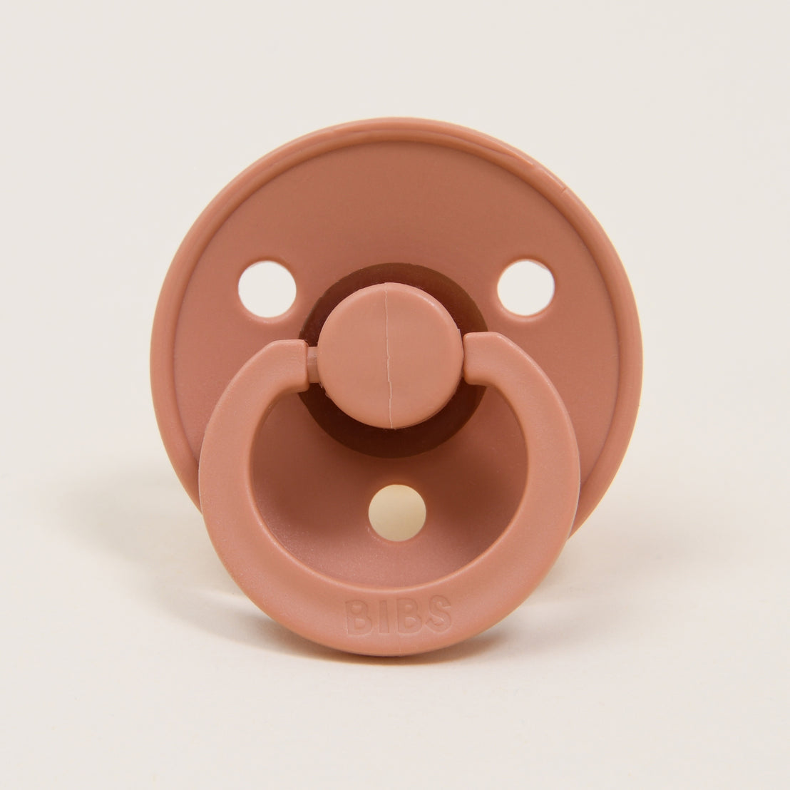 A close-up image of a Bibs pacifier in Peach Sunsest, displayed against a plain white background.