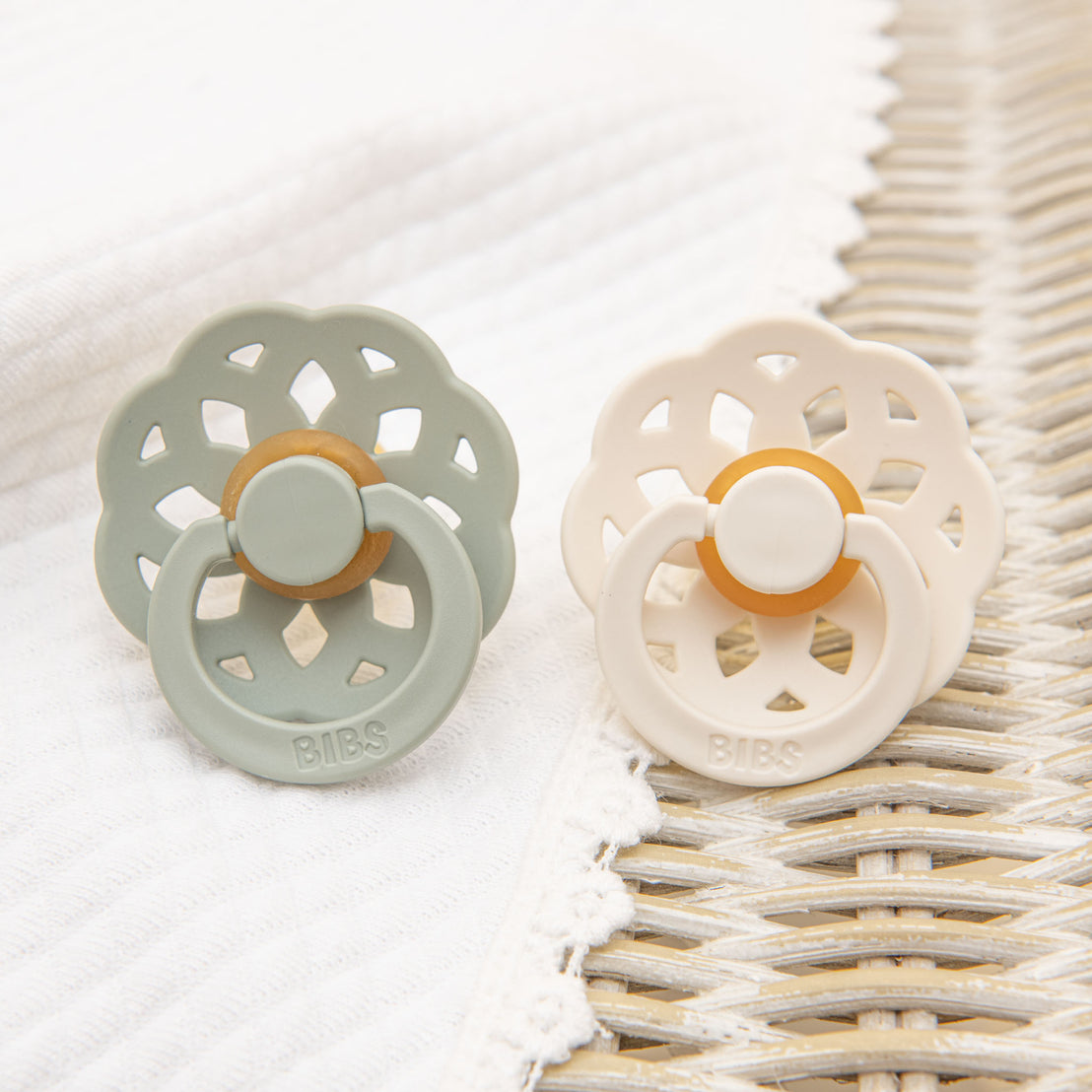 A flat lay photo of the Ella Pacifier Set in sage and ivory.