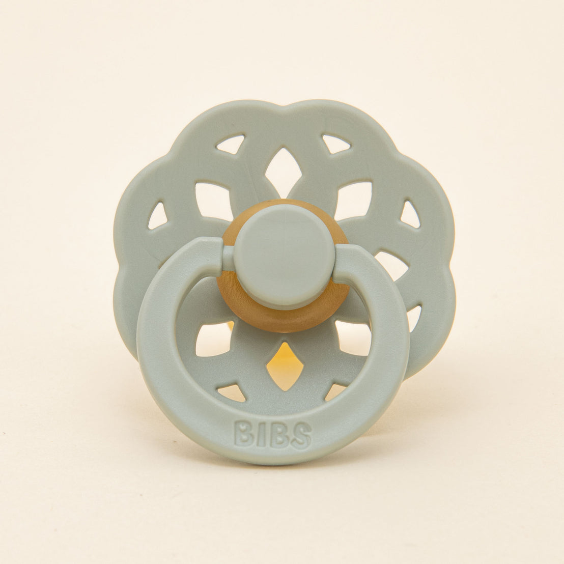 A close-up flat lay photo of the sage pacifier from the Ella Pacifier Set.