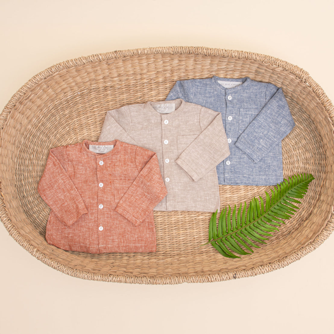 Flat lay photo of all three colors of the Silas Linen Shirt. The collarless shirt is a made from linen in three different colors: indigo, sand, and clay.