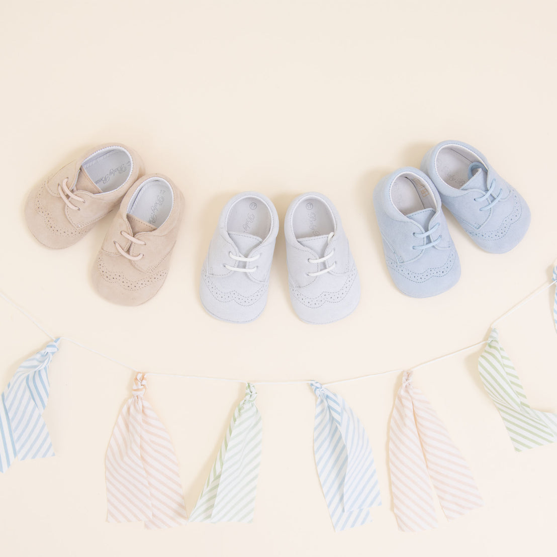 Flat lay photo of three pairs of Theodore Suede Shoes. Made from 100% suede with detailed edging. Available in colors blue, grey, and tan.