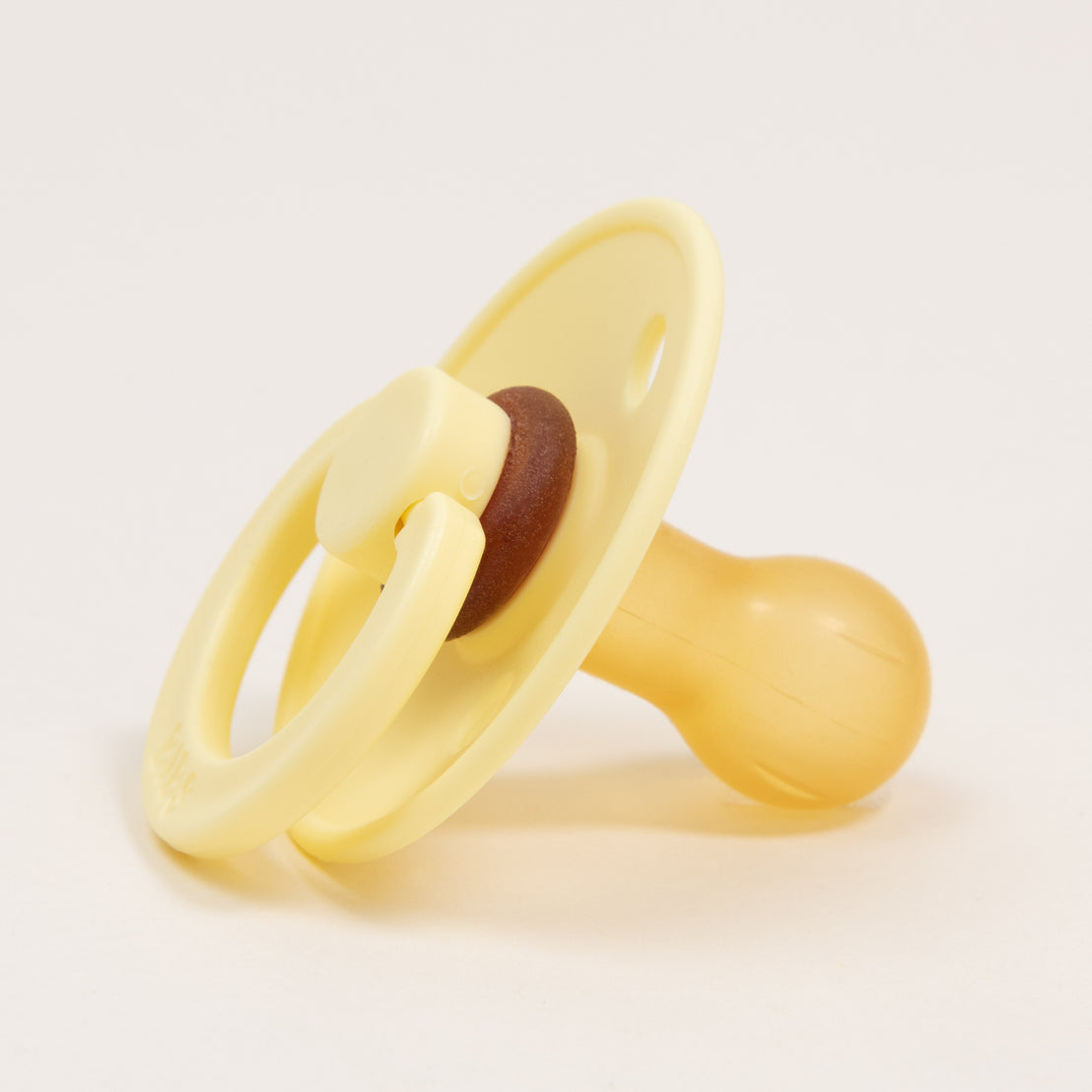 A yellow Bibs Pacifier in "sunshine" color with a natural nipple and brown handle, isolated on a white background.