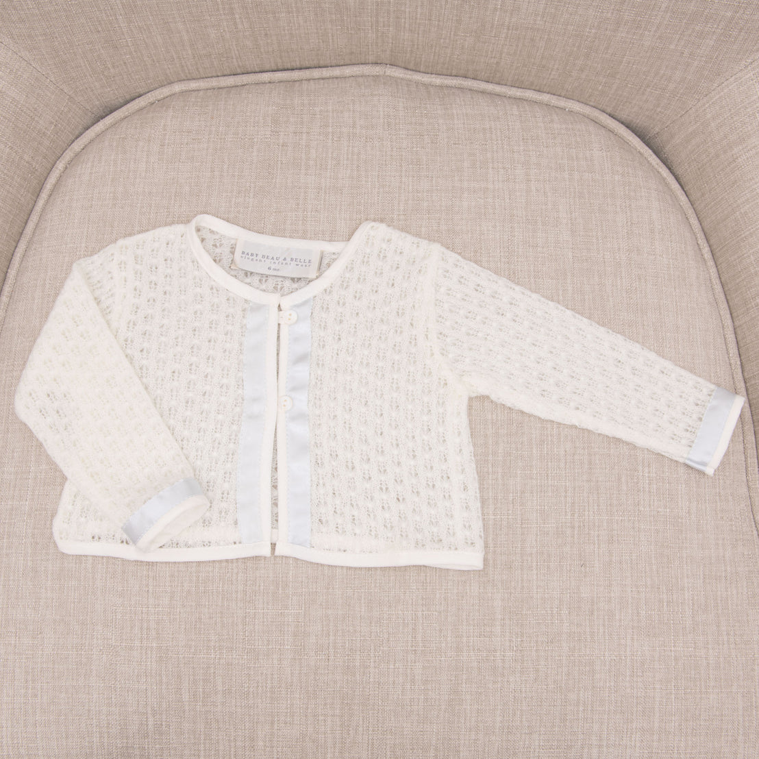 Flat lay photograph of the Rowan knit boys baptism sweater.