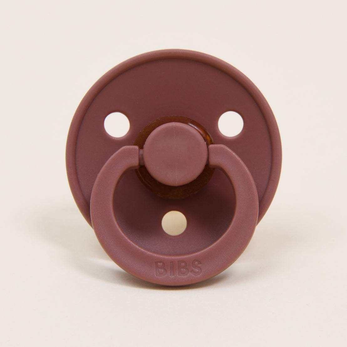 A close-up image of a Bibs Pacifier  in Woodchuck, featuring a round natural nipple. The brand "bibs" is embossed at the top.